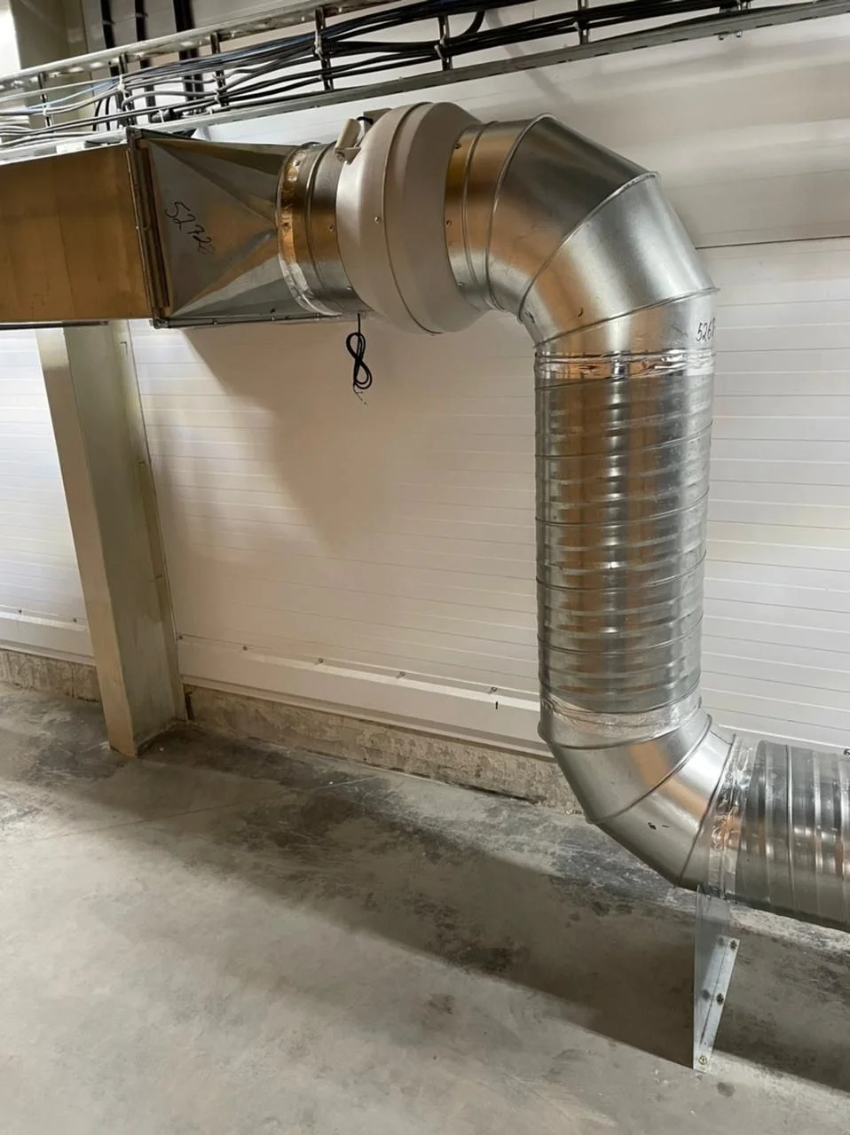 Close view of a galvanized CO2 removal duct elbow and fan connection