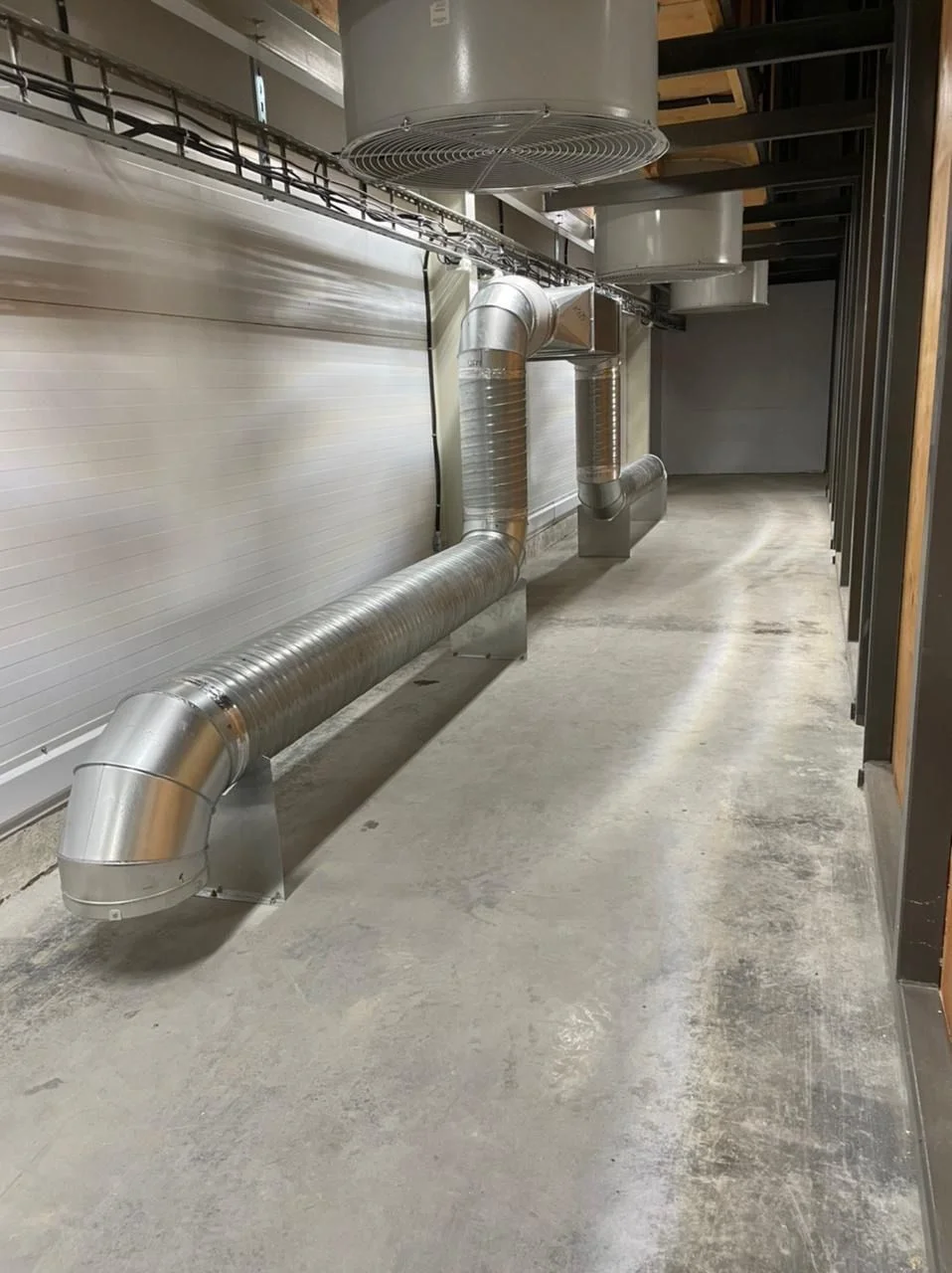 Vegetable storage CO2 exhaust duct connected to a fan and wall outlet